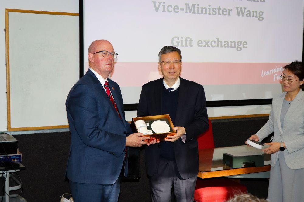 Vice Minster Wang and Headmaster Graeme Yule exchange a gift