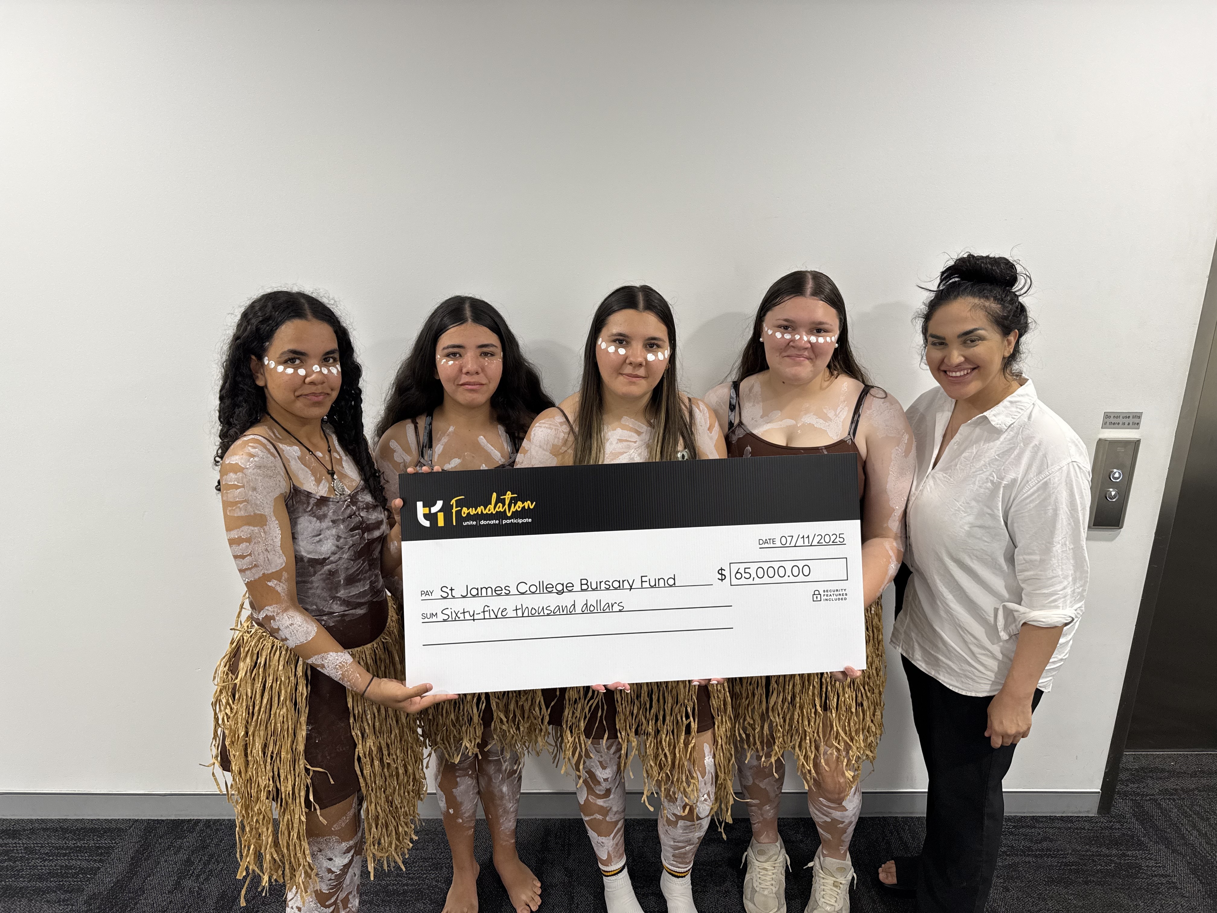 Students receiving a cheque from Technology One