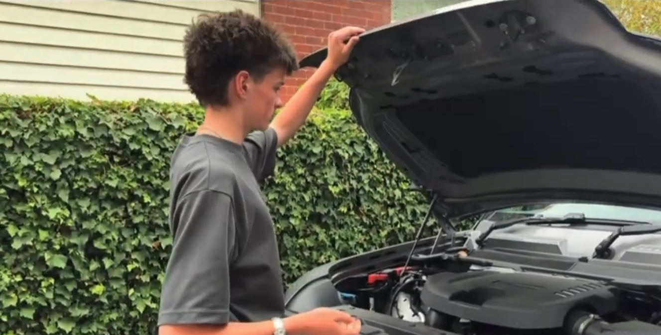 a st michael's student inspects the hood of his family car at his house as part of a road safety assessment task